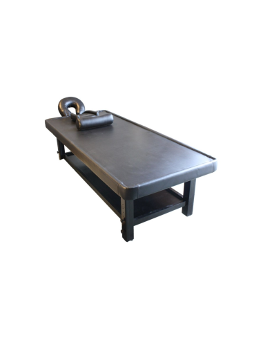 Ayurvedic massage table in dark wood, comfort and design for beauticians