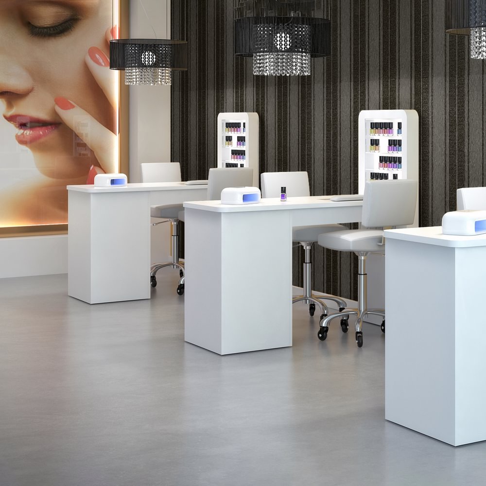 Espace showroom onglerie design avec tables manucure professionnelles blanches, chaises ergonomiques et présentoirs à vernis – aménagement haut de gamme pour institut de beauté.